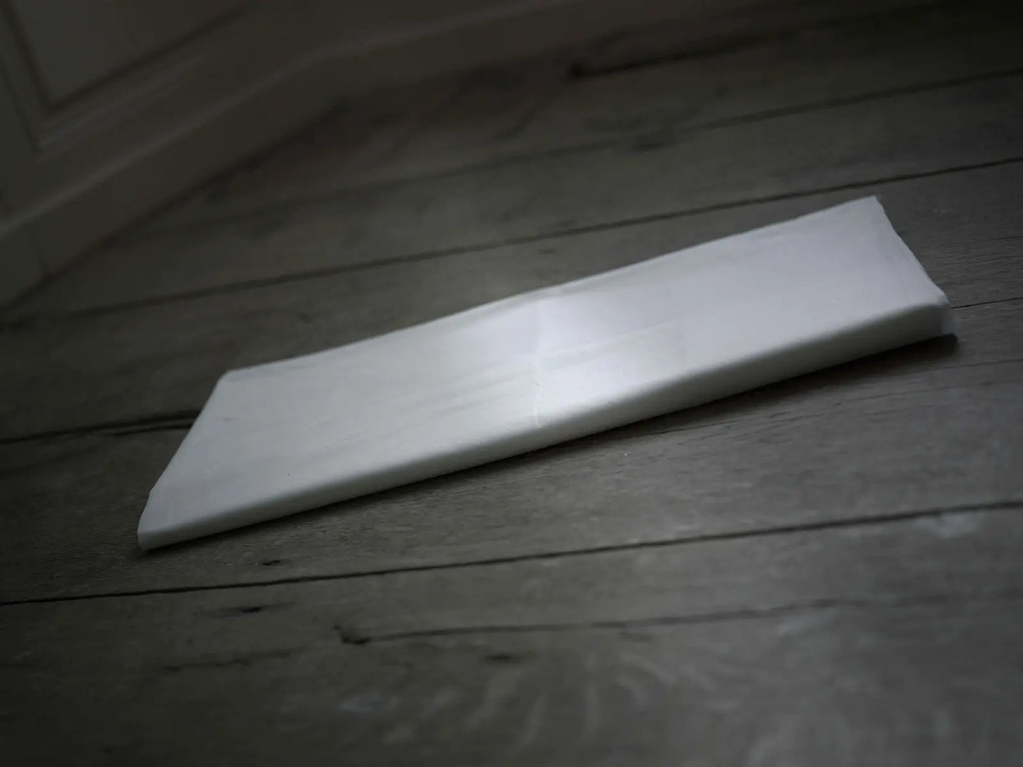 Housse de protection d'un surmatelas pliée sur le sol